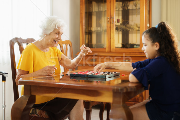 Grandma Playing Checkers Board Game With Granddaughter At Home Stock photo © diego_cervo