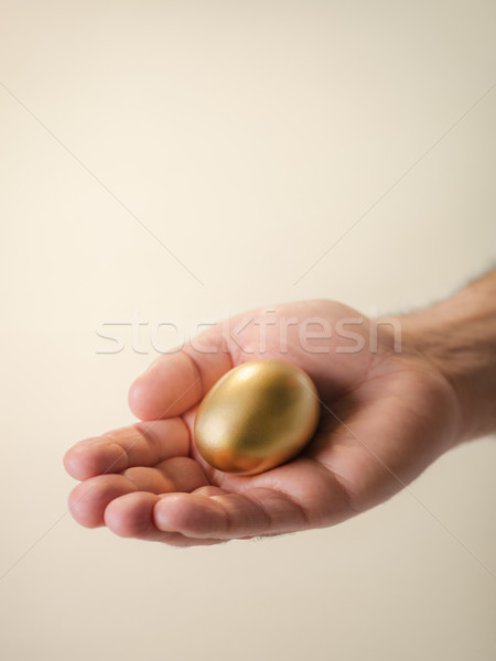 Man showing golden eggs, symbol of money saving Stock photo © diego_cervo