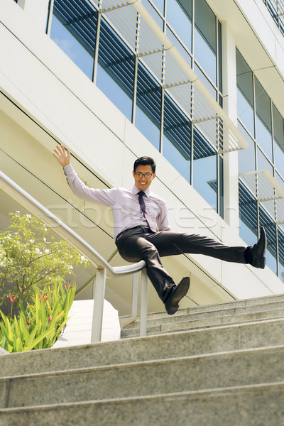 Happy Chinese Businessman Going Downstairs Sliding On Rail Stock photo © diego_cervo