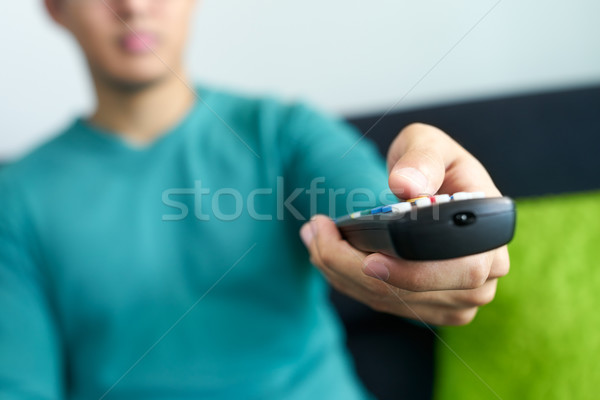 Asian Man Watches TV Changes Channel Holding Remote Control Stock photo © diego_cervo