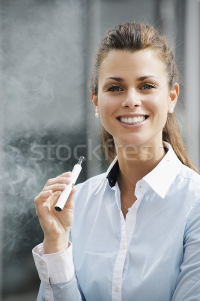 portrait of young woman smoking electronic cigarette outdoor off Stock photo © diego_cervo