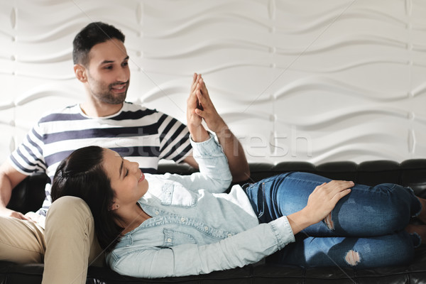 Happy Latino Couple Holding Hands And Smiling On Sofa Stock photo © diego_cervo