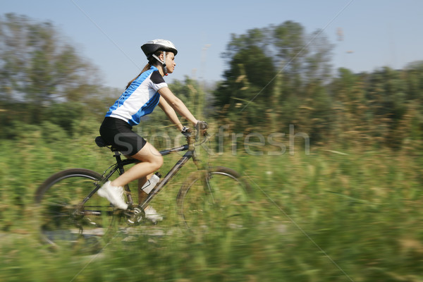 young woman training on mountain bike and cycling in park Stock photo © diego_cervo