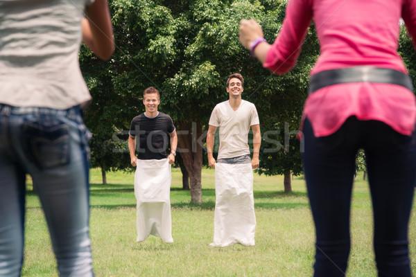 men playing sack race with girlfriends cheering Stock photo © diego_cervo