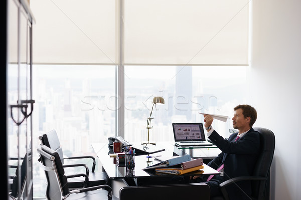 Bored Business Man Throwing Paper Airplane In Office Stock photo © diego_cervo
