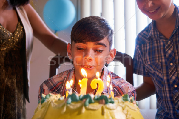 Birthday Party With Happy Latino Boy Blowing Candles On Cake Stock photo © diego_cervo