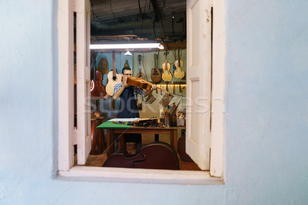 Stock photo: Lute Maker Checking Classic Guitar In Atelier Of Music Instrumen