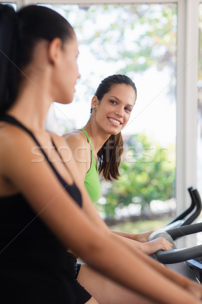 Pretty young girls training on fitness bikes in gym Stock photo © diego_cervo