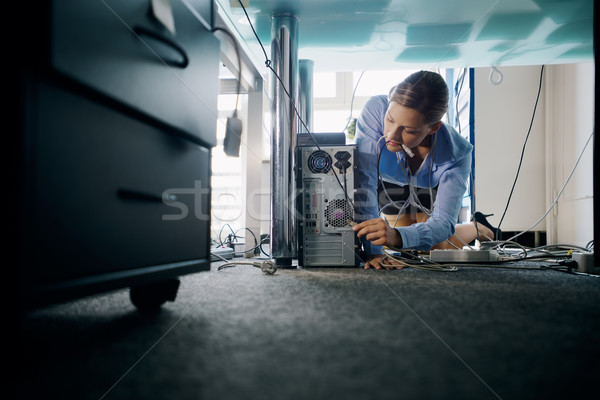 Young secretary connecting cables to pc in office Stock photo © diego_cervo