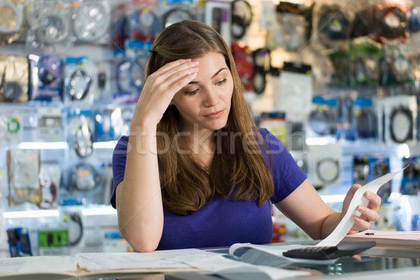 Worried Woman Checking Bills And Invoices In Computer Shop Stock photo © diego_cervo