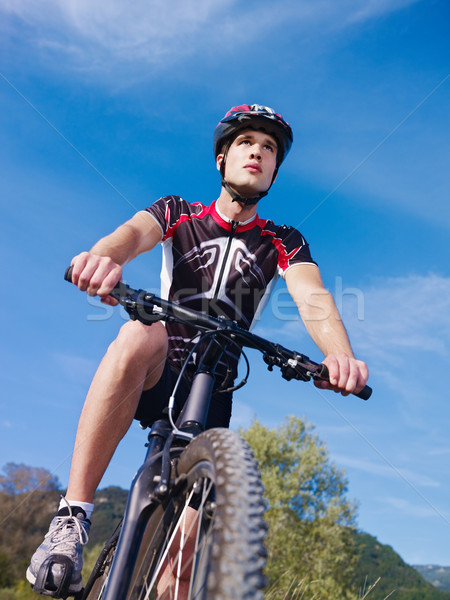 Stock photo: young man training on mountain bike 