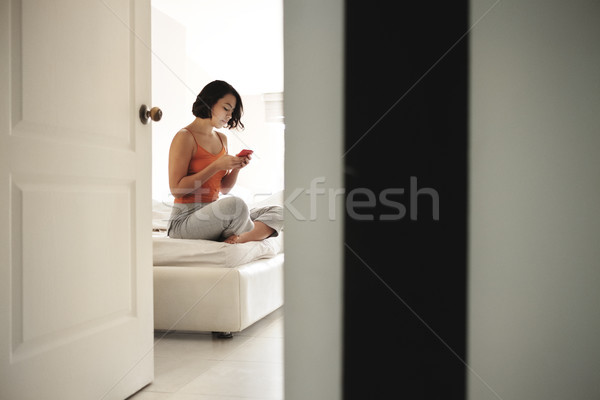 Kadın sosyal medya telefon koyu esmer oturma yatak Stok fotoğraf © diego_cervo