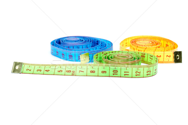 Three rolled measuring tapes of different colors Stock photo © digitalr