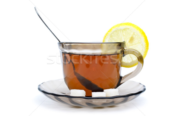 Teacup with black tea, teaspoon, dish, lemon slice and some sugar pieces Stock photo © digitalr