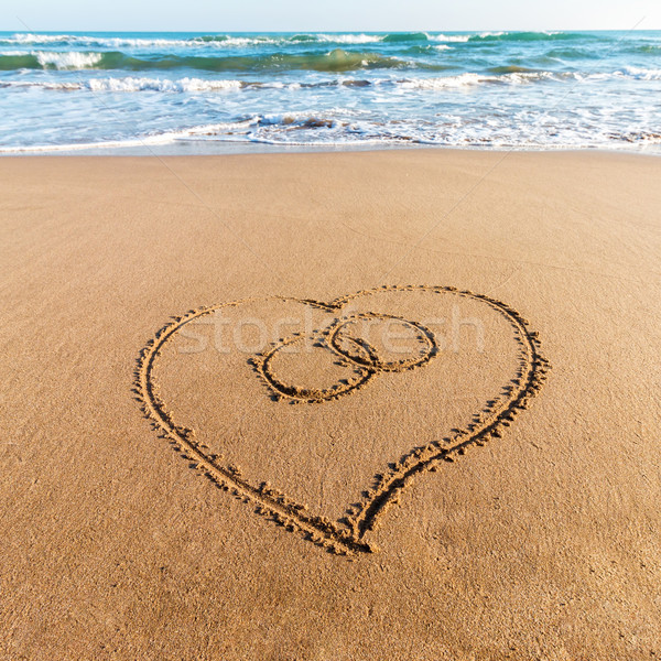 Drawing heart on the sand Stock photo © digoarpi