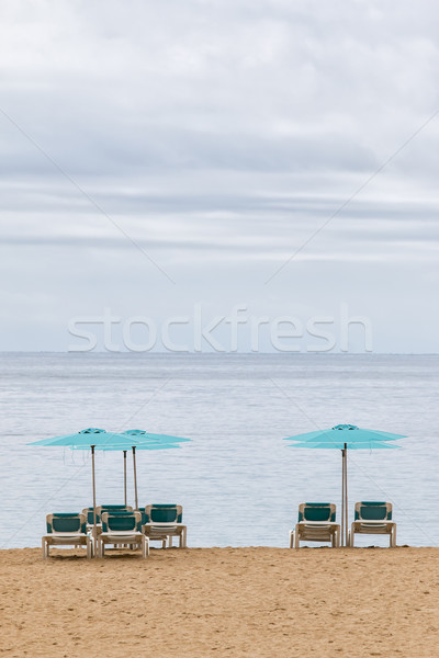 Sunbeds are waiting for tourists on the beach Stock photo © digoarpi