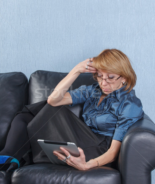 middle aged woman using tablet PC on couch Stock photo © Discovod