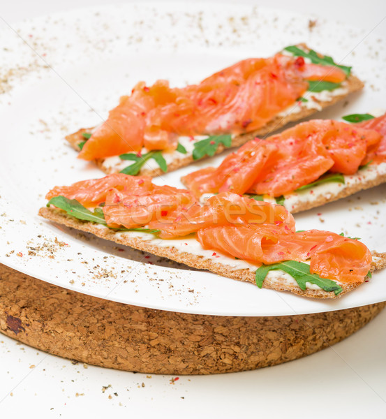 Salted salmon on crispy bread with cheese and arugula Stock photo © Discovod