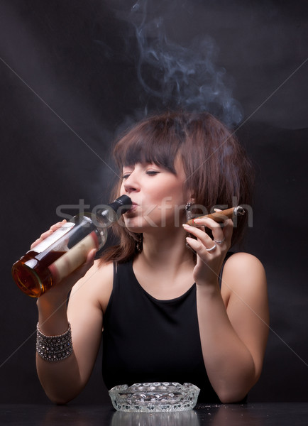 woman drinks alcohol and smokes a cigar Stock photo © Discovod
