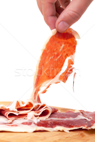 Thinly Sliced ​​Spanish Jamon with a Hand Stock photo © Discovod