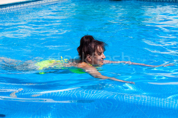 Middle-aged woman swims in the swimming pool Stock photo © Discovod