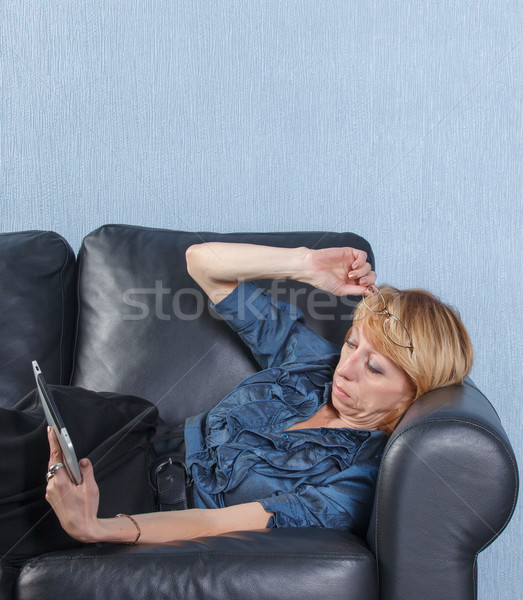 middle aged woman using tablet PC on couch Stock photo © Discovod