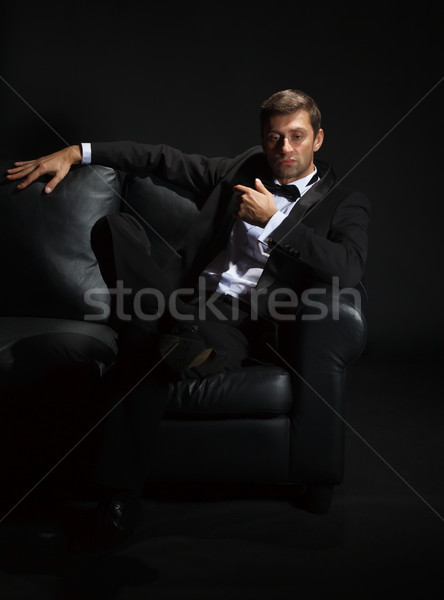 Handsome man in a tuxedo on couch Stock photo © Discovod