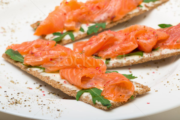 Salted salmon on crispy bread with cheese and arugula Stock photo © Discovod