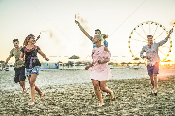 Csoport boldog barátok fut tengerpart tűzijáték Stock fotó © DisobeyArt