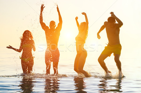 Jongeren zwemmen zonsopgang partij strand groep Stockfoto © DisobeyArt