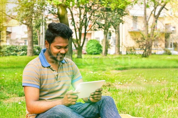 Young indian man having video call on tablet in park university  Stock photo © DisobeyArt