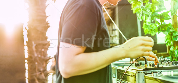 Dj mixing outdoor with back sun light - Disc jockey playing viny Stock photo © DisobeyArt