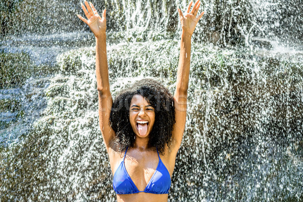 Young african descent woman having fun under river waterfalls -  Stock photo © DisobeyArt