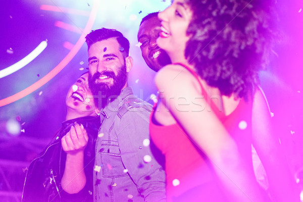 Happy friends having fun in night club with canon ball throwing  Stock photo © DisobeyArt