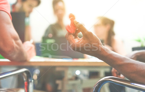 Black man playing with fidget spinner for anti stress at startup Stock photo © DisobeyArt