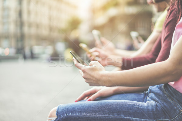 Stock photo: Group of teenagers friends watching mobile phones in city - Youn
