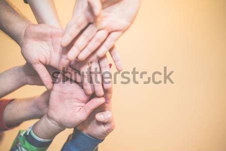 Close up bottom view of young people putting their hands togethe Stock photo © DisobeyArt