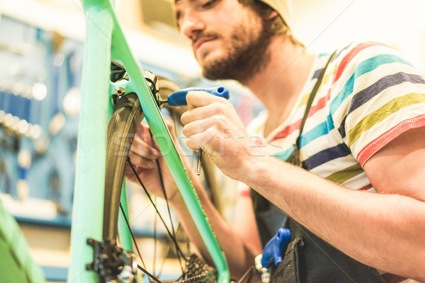 Bearded bicycle mechanic doing his professional work in workshop Stock photo © DisobeyArt