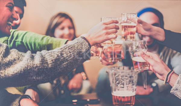 Happy friends toasting beers and laughing at chalet pub in mount Stock photo © DisobeyArt