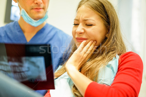 Young woman with teeth pain looking x-ray in dental clinic with  Stock photo © DisobeyArt