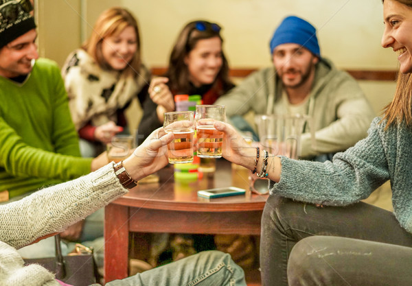 Group of happy friends cheering with beer after skiing day in ba Stock photo © DisobeyArt
