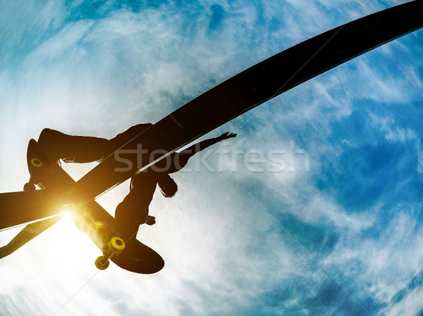 Silhouette of young skater performing tricks and skills on ramp  Stock photo © DisobeyArt