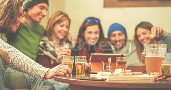 Happy friends toasting beers and watching videos on tablet at ch Stock photo © DisobeyArt