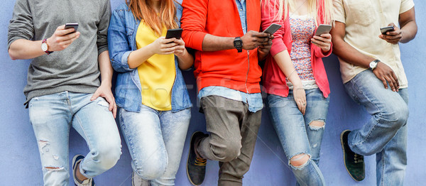 Group of multiracial students watching smart mobile phones in un Stock photo © DisobeyArt