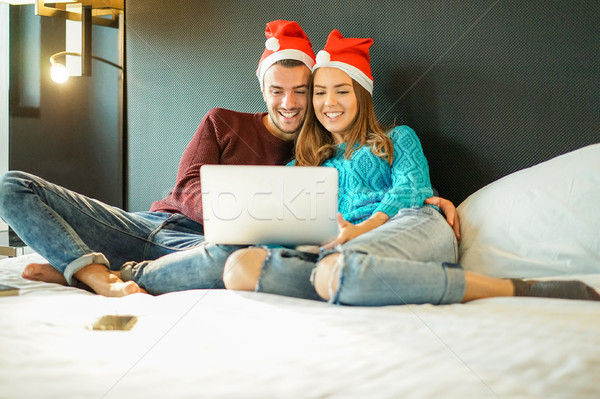 Happy couple buying christmas presents online with laptop comput Stock photo © DisobeyArt