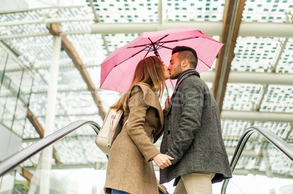 Two lovers kissing each others on mall shopping centre escalator Stock photo © DisobeyArt