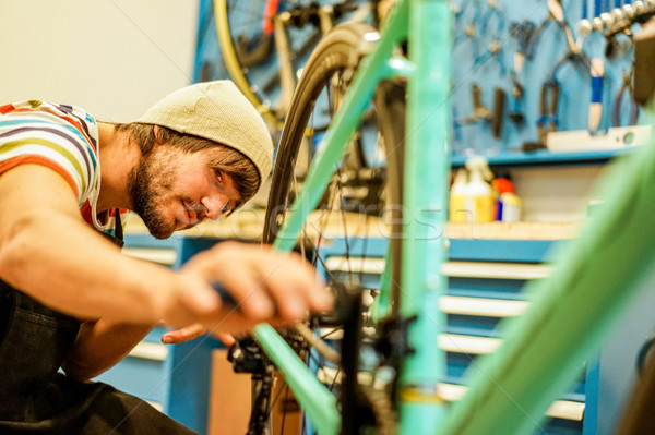 Stylish bearded bicycle mechanic doing his professional work in  Stock photo © DisobeyArt