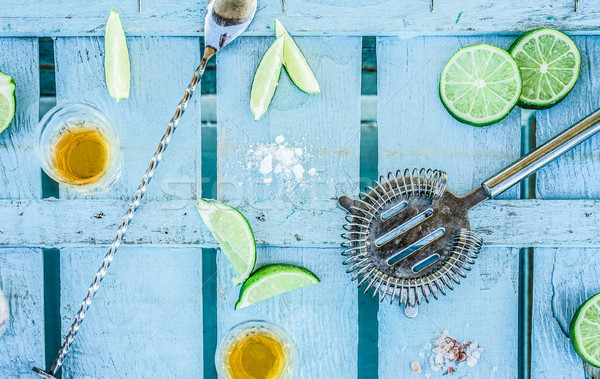Top view of tequila shots with limes and salt on blue wood bar c Stock photo © DisobeyArt