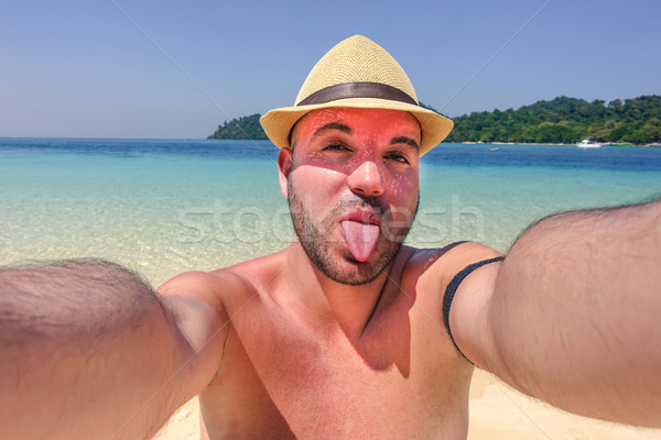 Happy man on vacation making funny face at the beach taking self Stock photo © DisobeyArt