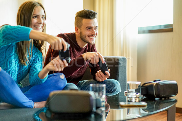 Happy friends playing video games with virtual reality glasses - Stock photo © DisobeyArt